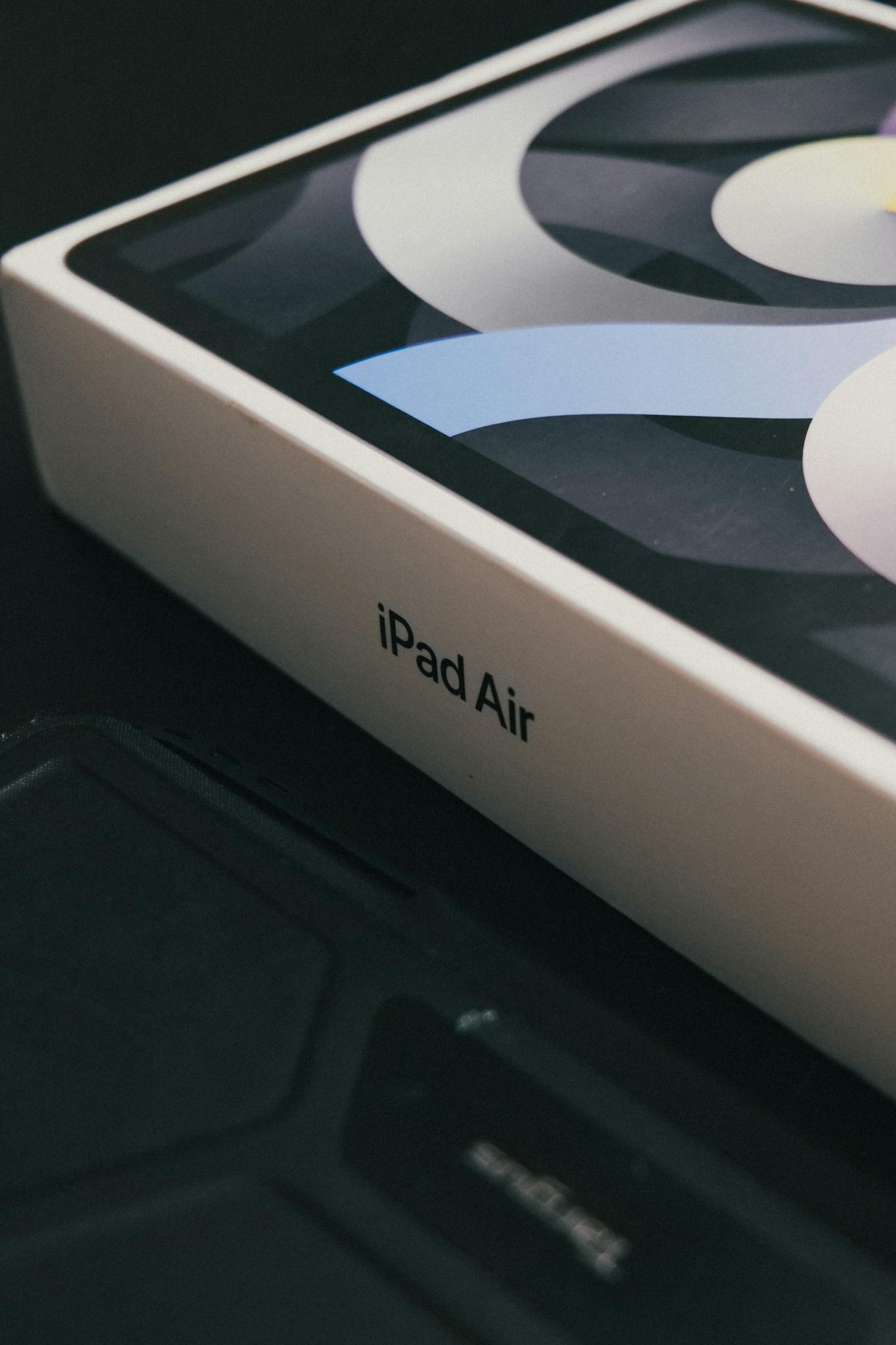 Focused view of iPad Air box displaying brand packaging on a dark background.